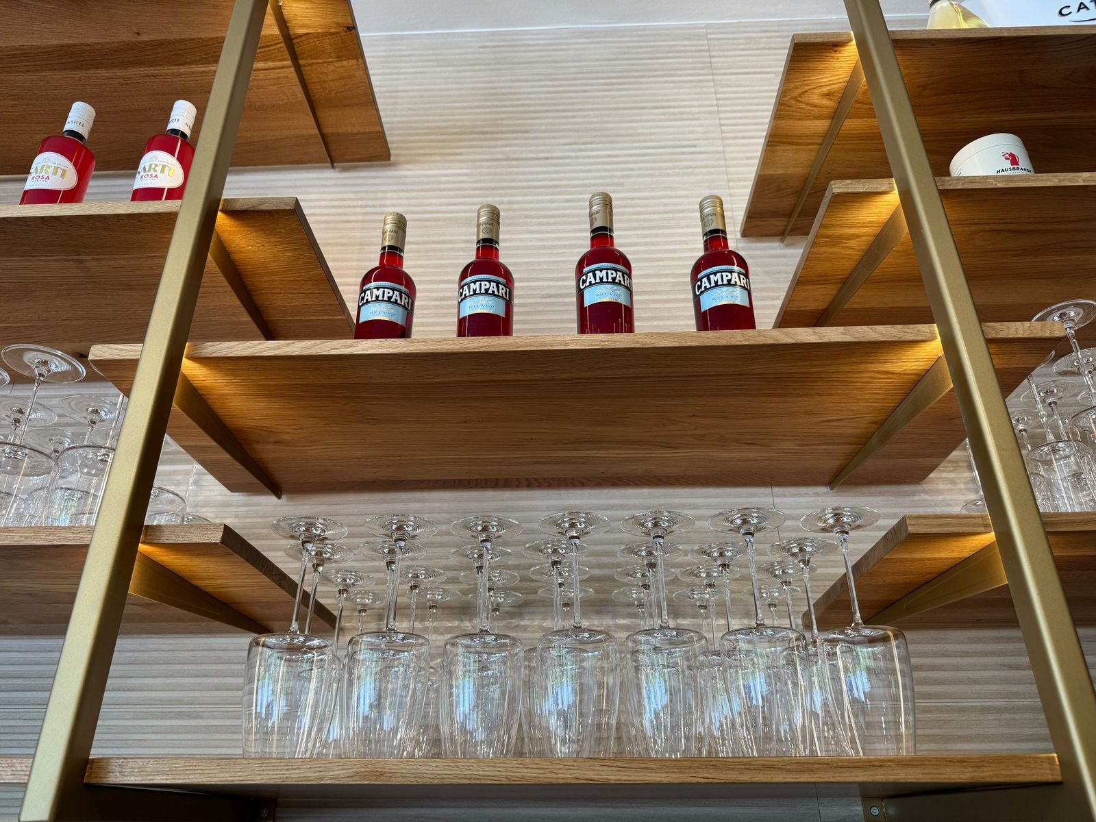 Regal mit Campari, Gläsern und Bar-Zubehör